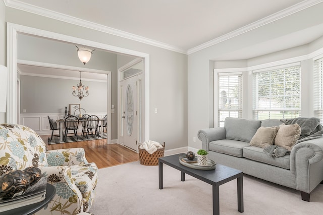 living room with a chandelier, light hardwood / wood-style flooring, and ornamental molding