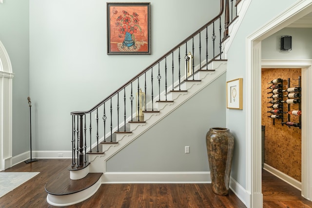 staircase featuring baseboards and wood finished floors