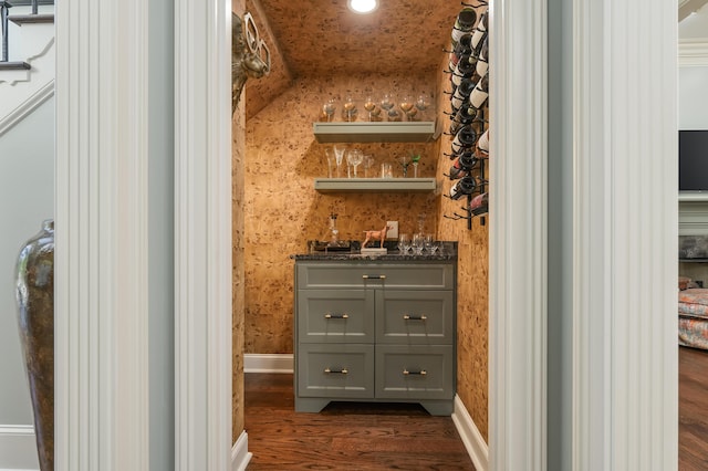 bar with baseboards, indoor wet bar, recessed lighting, and dark wood-type flooring