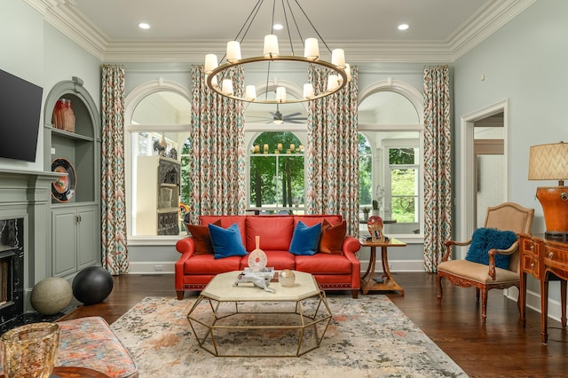 living area featuring crown molding, baseboards, wood finished floors, and ceiling fan with notable chandelier
