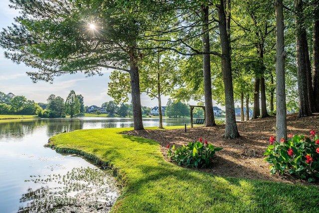 surrounding community with a lawn and a water view