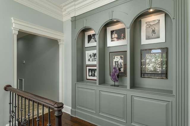 interior details with crown molding, baseboards, built in features, and wood finished floors