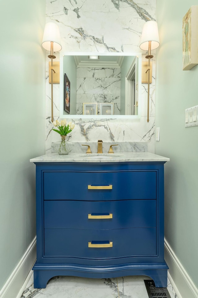 bathroom with vanity, marble finish floor, and baseboards