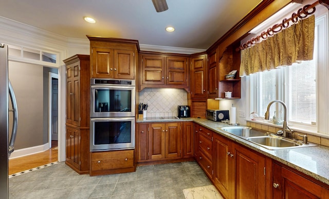 kitchen with appliances with stainless steel finishes, decorative backsplash, a sink, and ornamental molding