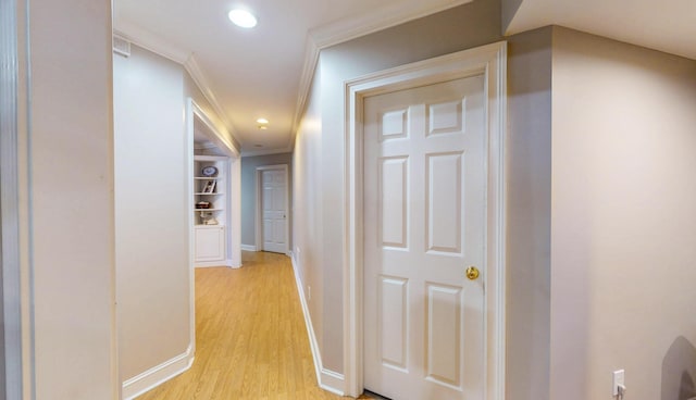 hallway featuring baseboards, ornamental molding, light wood-type flooring, and recessed lighting