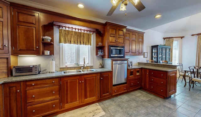 kitchen featuring appliances with stainless steel finishes, a sink, a wealth of natural light, and a toaster