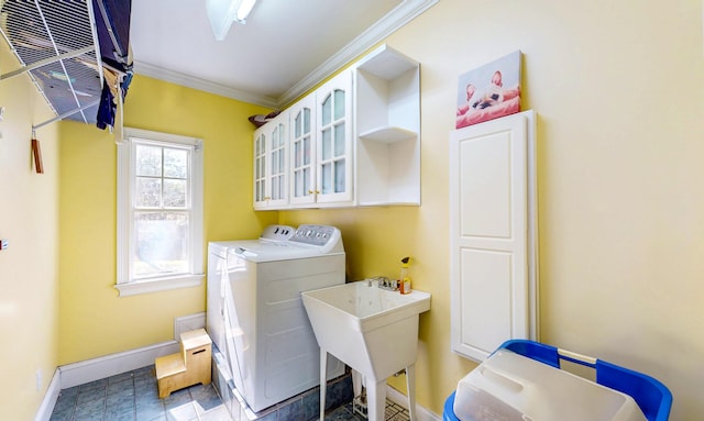 laundry room featuring crown molding, washer and clothes dryer, a sink, laundry area, and baseboards