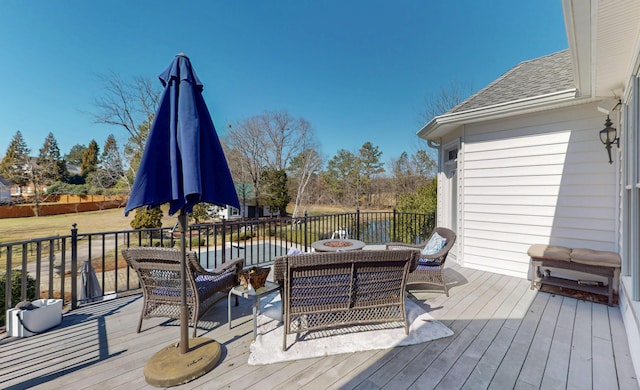 wooden deck with a water view and outdoor lounge area