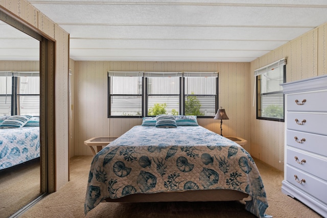 bedroom featuring light colored carpet and wood walls