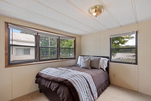 carpeted bedroom featuring wallpapered walls