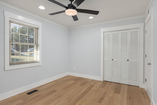 unfurnished bedroom featuring crown molding, ceiling fan, light hardwood / wood-style floors, and a closet