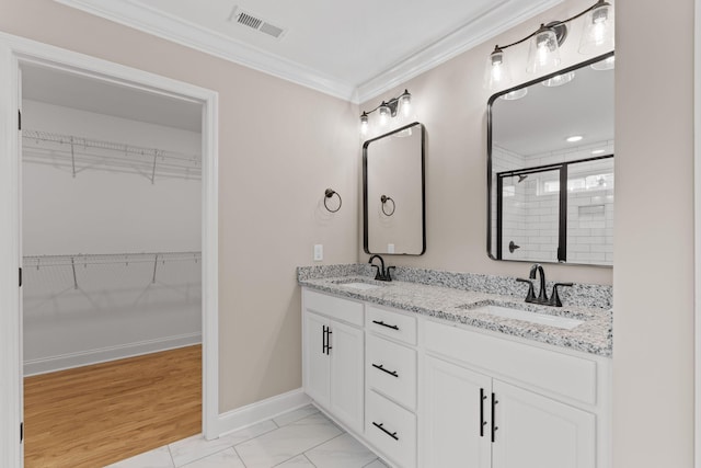 bathroom with crown molding, vanity, and an enclosed shower