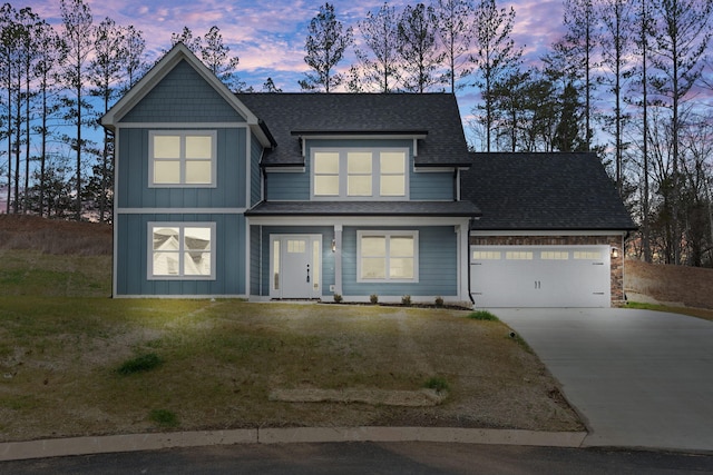 view of front of home featuring a lawn and a garage