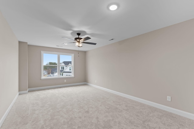 carpeted spare room featuring ceiling fan