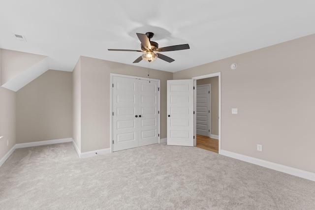 unfurnished bedroom featuring ceiling fan, light carpet, and a closet