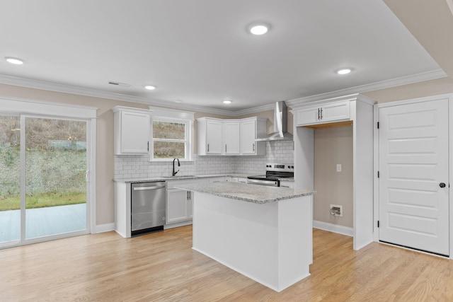 kitchen featuring white cabinetry, wall chimney range hood, backsplash, and appliances with stainless steel finishes