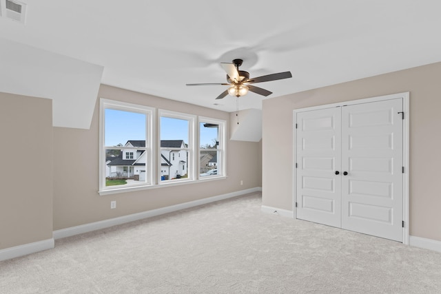 additional living space with ceiling fan and light carpet