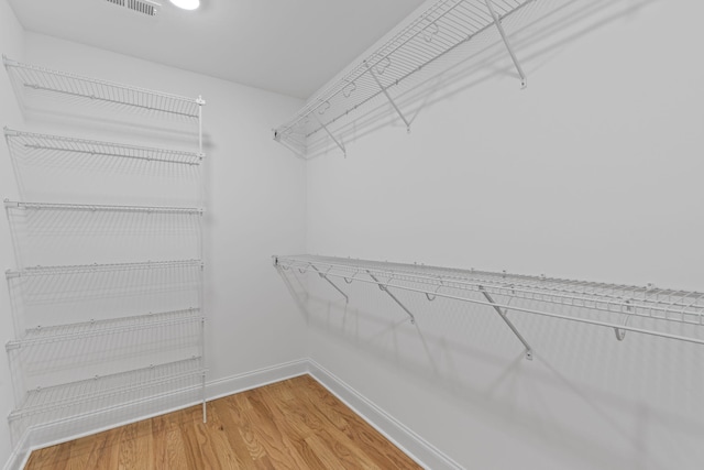 spacious closet with hardwood / wood-style flooring