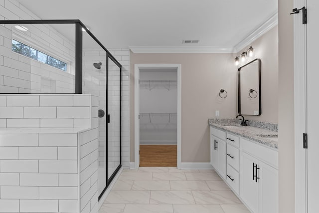 bathroom with vanity, a shower with shower door, and crown molding