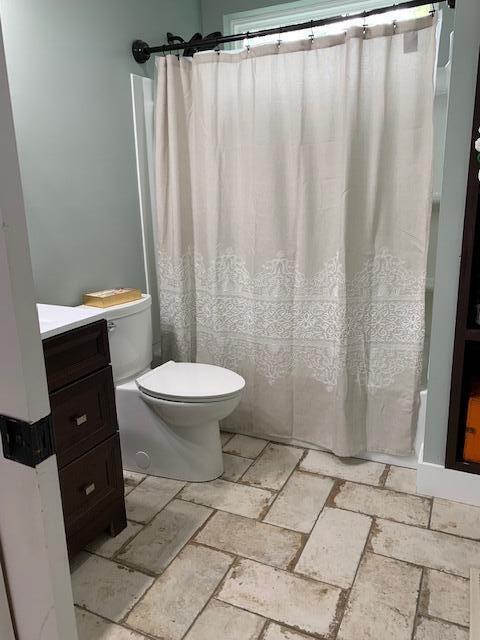 bathroom featuring a shower with curtain, vanity, and toilet