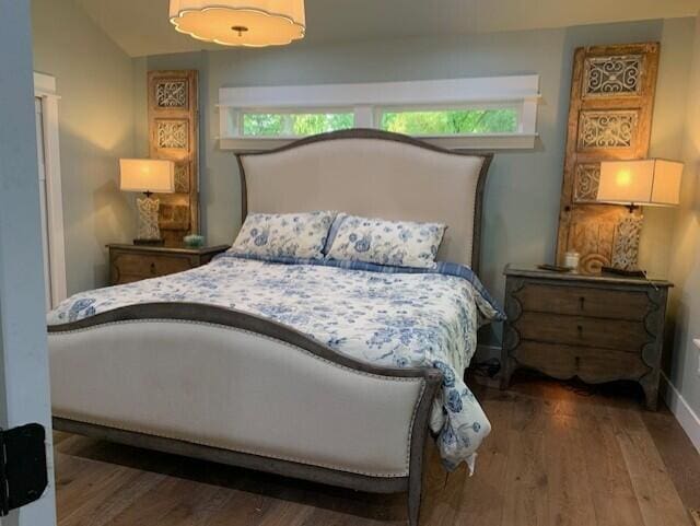 bedroom with vaulted ceiling and dark hardwood / wood-style floors