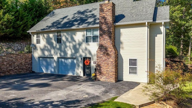 436 Oak Hills Drive Lots 4.5 & 6, Spring City, TN 37381 - view of home's exterior featuring asphalt driveway, a chimney, a garage, and roof with shingles
