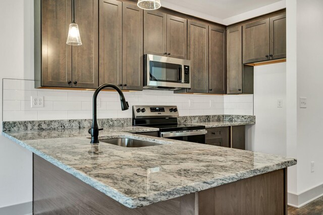 164 Mcnabb Dr, Cleveland, TN 37312 - kitchen featuring a sink, light stone counters, dark brown cabinetry, and appliances with stainless steel finishes