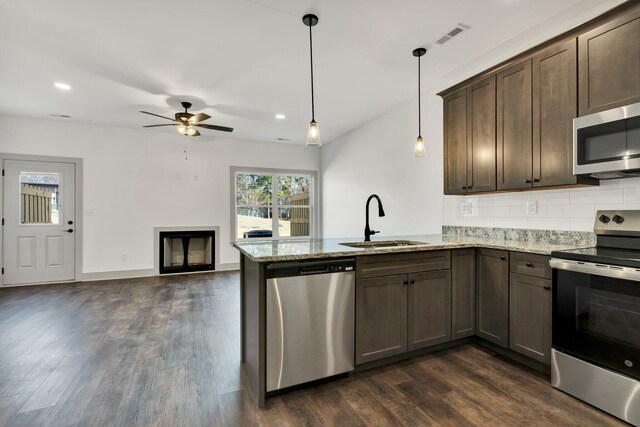 164 Mcnabb Dr, Cleveland, TN 37312 - kitchen with dark wood finished floors, a peninsula, a sink, stainless steel appliances, and dark brown cabinetry