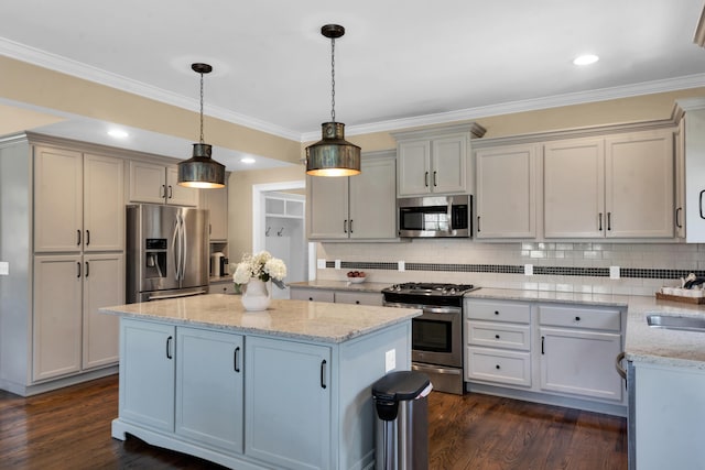 kitchen with a sink, tasteful backsplash, a kitchen island, dark wood-style floors, and appliances with stainless steel finishes