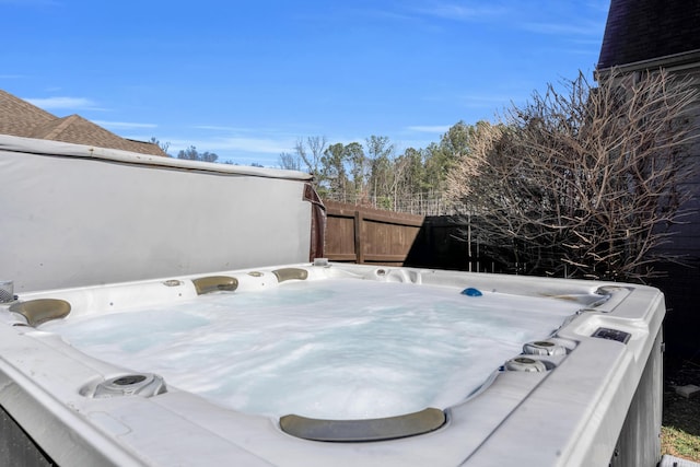 wooden deck featuring a hot tub and fence