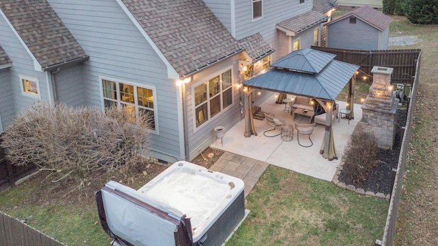 exterior space with a patio, a gazebo, fence, and a shingled roof