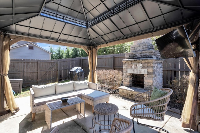 view of patio featuring a gazebo, an outdoor living space with a fireplace, and a fenced backyard