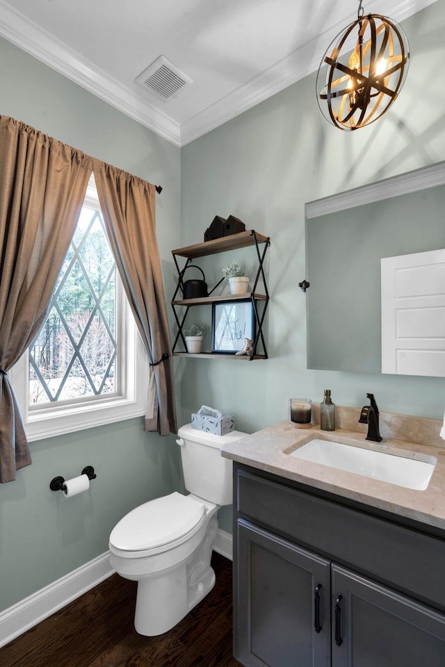 bathroom featuring visible vents, toilet, ornamental molding, wood finished floors, and vanity