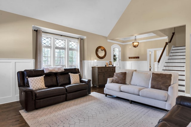 living room with wainscoting, high vaulted ceiling, stairs, and wood finished floors