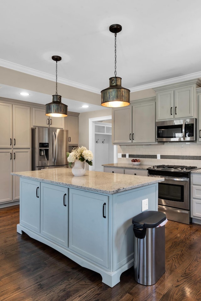 kitchen with decorative backsplash, ornamental molding, a kitchen island, and stainless steel appliances