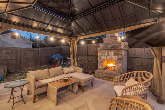 view of patio with a gazebo, an outdoor living space with a fireplace, and a fenced backyard