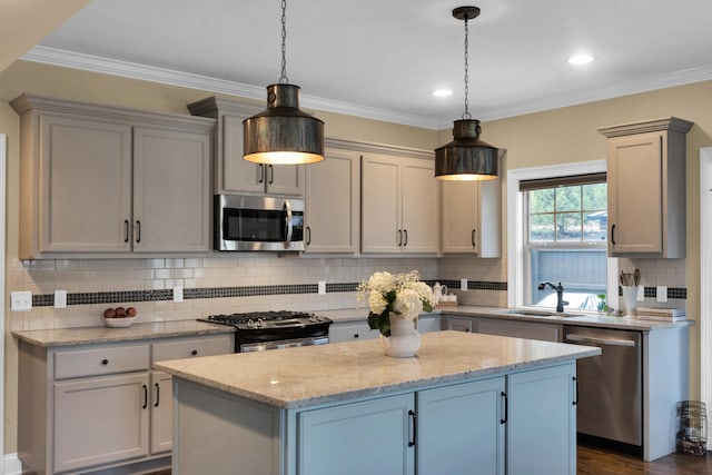 kitchen featuring a sink, a center island, appliances with stainless steel finishes, crown molding, and decorative backsplash