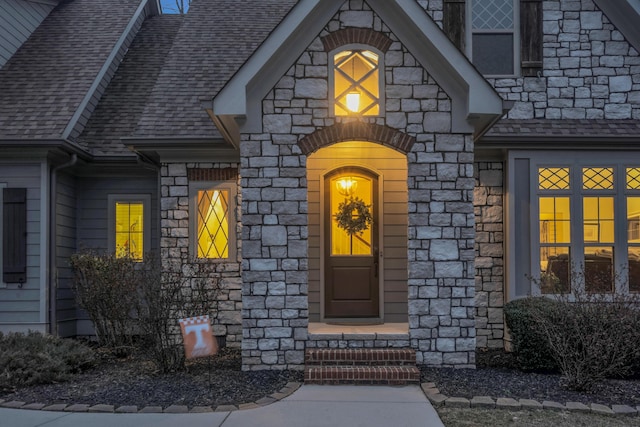 property entrance with stone siding and roof with shingles