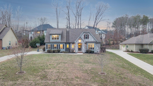 view of front facade with stone siding, concrete driveway, and a front yard