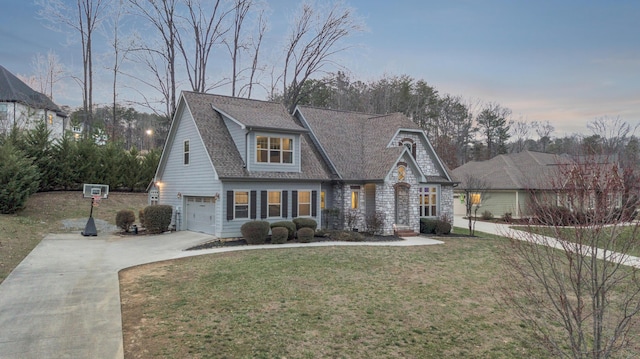 view of front of home with an attached garage, driveway, a front yard, and roof with shingles