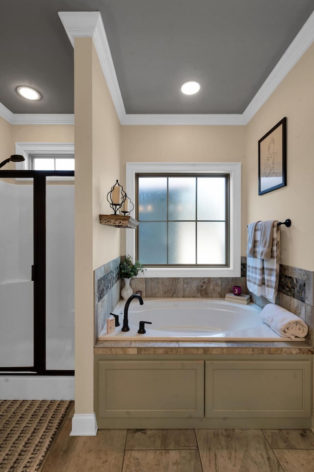 bathroom featuring a shower stall, crown molding, and a garden tub