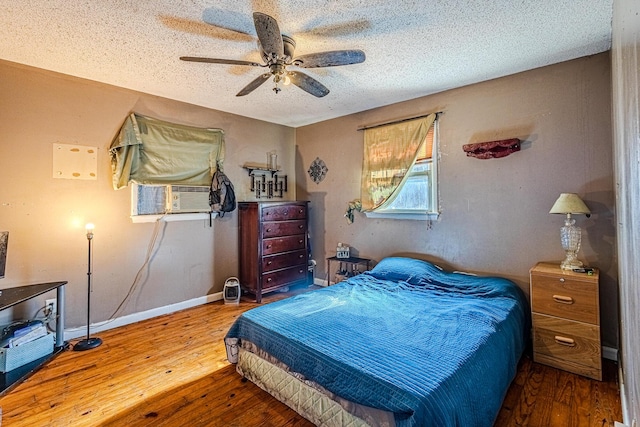 bedroom featuring ceiling fan, cooling unit, a textured ceiling, and hardwood / wood-style flooring