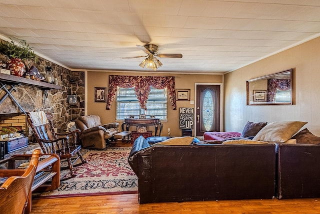 living room with light hardwood / wood-style floors, ornamental molding, and ceiling fan