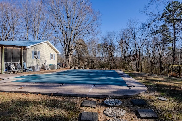 view of pool featuring central air condition unit and a patio