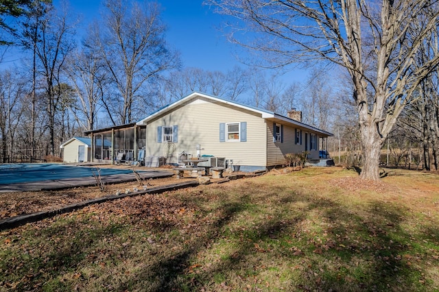 back of house featuring a covered pool, a patio, and a sunroom