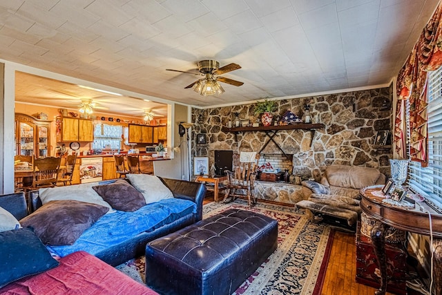 living room with ceiling fan, wood-type flooring, and ornamental molding