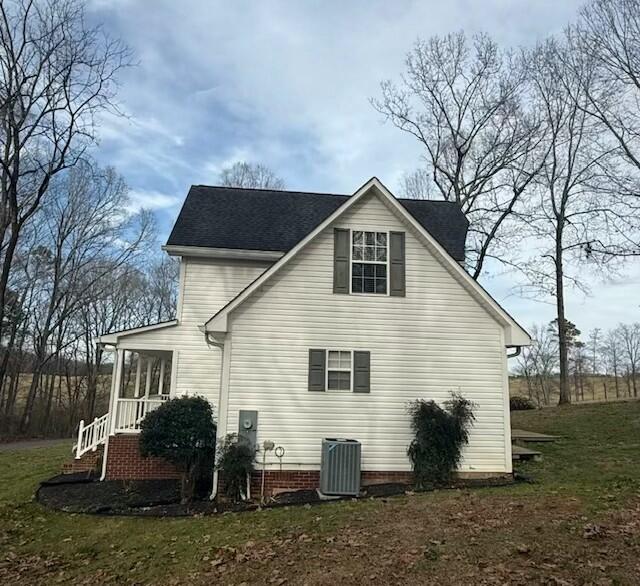 view of home's exterior featuring central AC unit and a yard