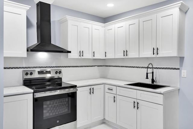 kitchen with backsplash, stainless steel electric stove, sink, wall chimney range hood, and white cabinetry