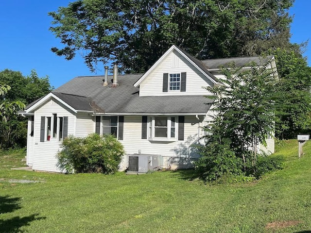 rear view of house featuring a yard and central AC unit