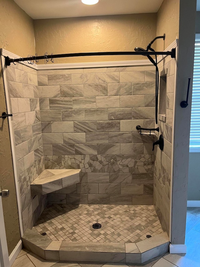 bathroom with tile patterned floors and a tile shower